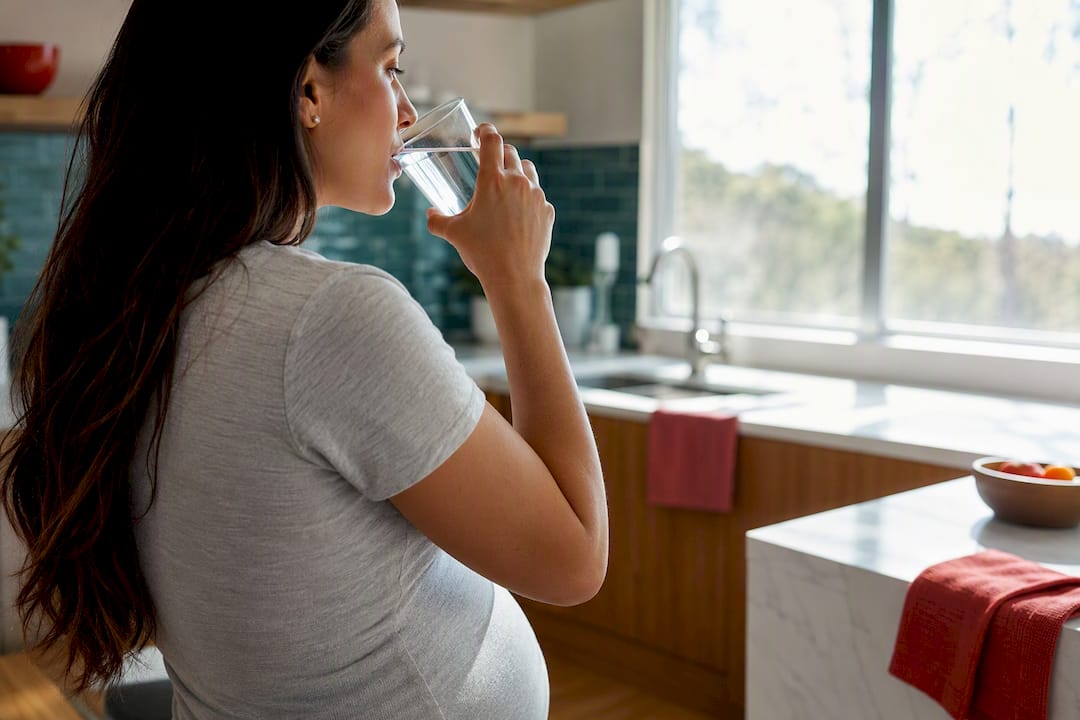 Pregnant woman taking a small sip of water