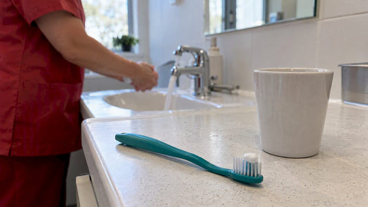 Pea-sized toothpaste beside toothbrush and rinse cup